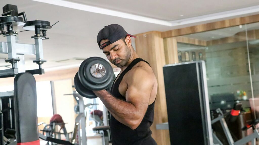 Man performing a controlled dumbbell bicep curl in the gym to build muscle