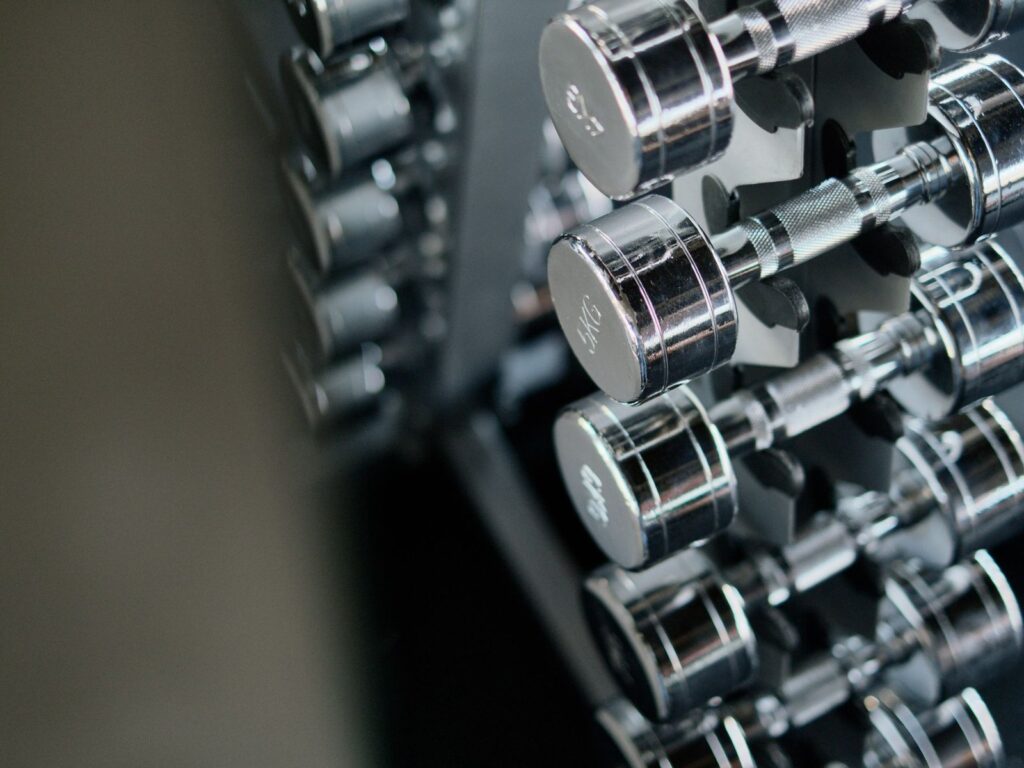 Chrome dumbbells neatly re-racked on a gym dumbbell rack.