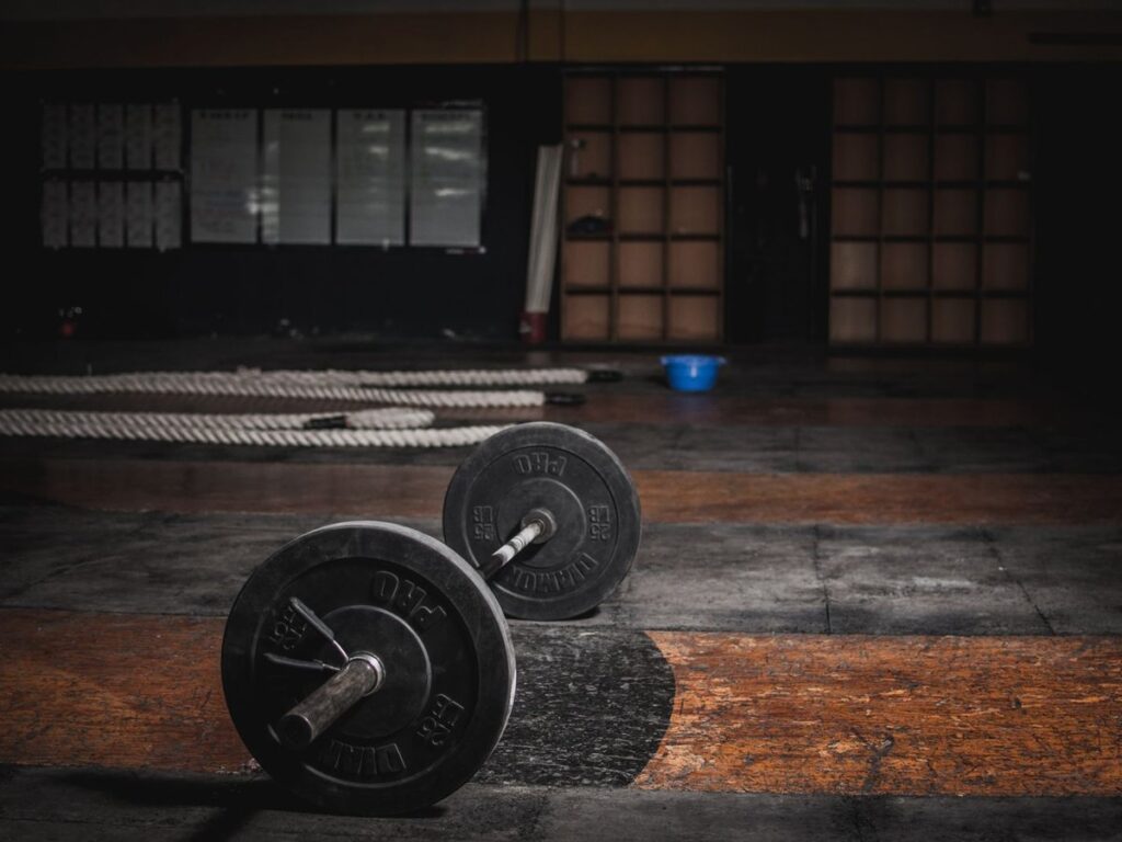 Loaded barbell on a dark gym floor