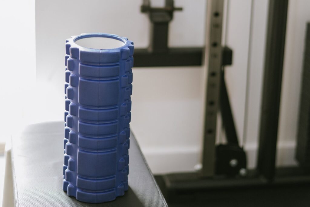 Blue foam roller on a gym bench, ready for a pre-workout warm-up