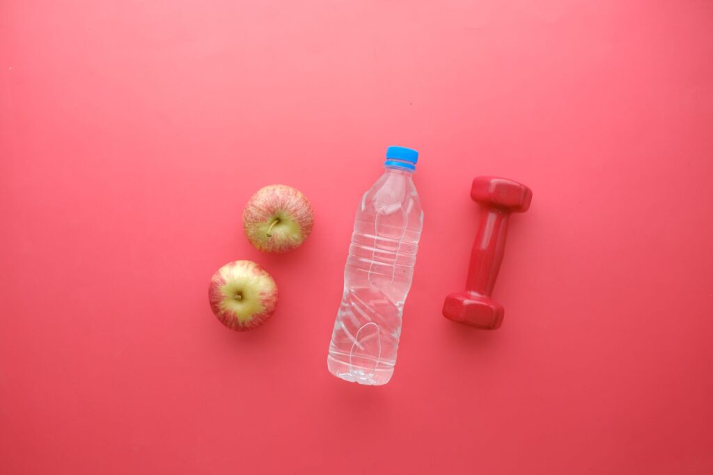 Apples, a water bottle and a dumbbell for a healthy weight loss plan